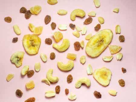 Dried fruits on the table. Pink background. Nuts