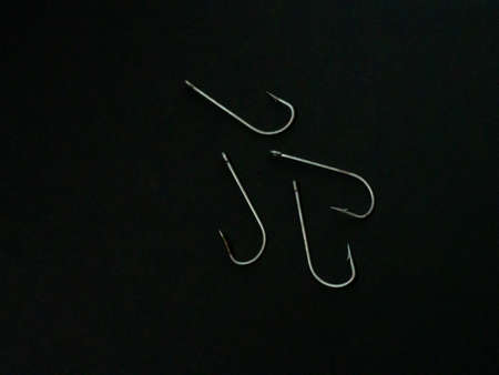 Large fishing hooks on a black background. Fishingの写真素材