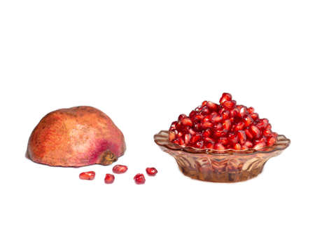 Plate with pomegranate seeds and half of pomegranate on white backgroundの写真素材