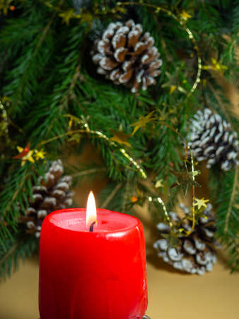 New Year's decorations. Pine cone, candle, and fir branches on a beige background. New Year.の写真素材