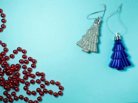 New Year card. Christmas card on a blue background.  Decorations for the holiday. Christmas toys. Red beads
and Christmas treesの写真素材