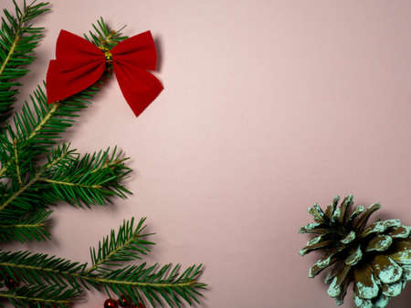 New Year card. Christmas card on a pink background. Decorations for the holiday.
Red bow, red beads and a fir cone.の写真素材