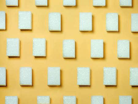 Sugar lumps on a yellow background. Sweet product. Sugar cubes background. Geometryの写真素材