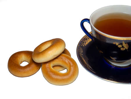 A cup of black tea with  sushki.
 A round bakery product with a hole.の写真素材