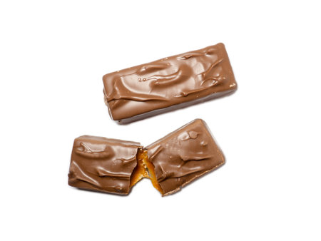 Broken chocolate bar on a white background. Slices of chocolate.Nougat and caramel.の写真素材