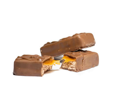 Broken chocolate bar on a white background. Slices of chocolate.Nougat and caramel.の写真素材