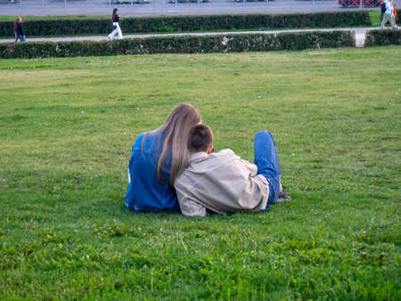 A couple of lovers are resting on the lawn in the park.の写真素材