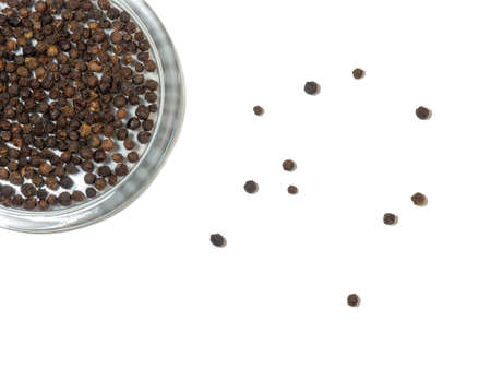 black peppercorns in a glass plate on a white background.の写真素材