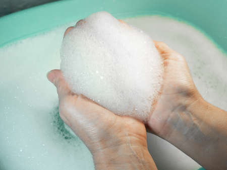 Foam in hands. Washing dishes. Washing basin. Handwashの写真素材