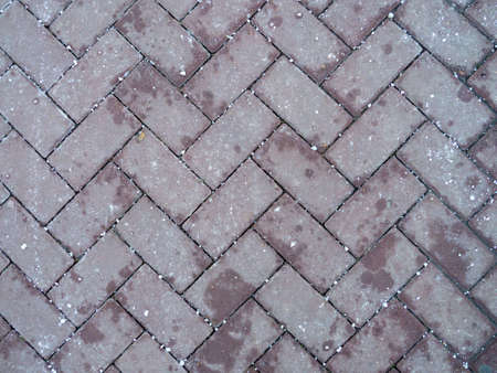 Road tiles. Asphalt  covered with snow. Masonry. made of solid material. Concrete. Patterned surfaceの写真素材