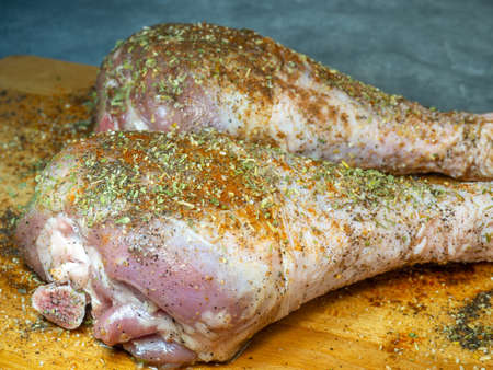 Turkey drumsticks in spices lie on a kitchen cutting board. Poultry meat. Turkey leg. Juicy meat is waiting to be cooked. Waiting for the oven. Hamの写真素材