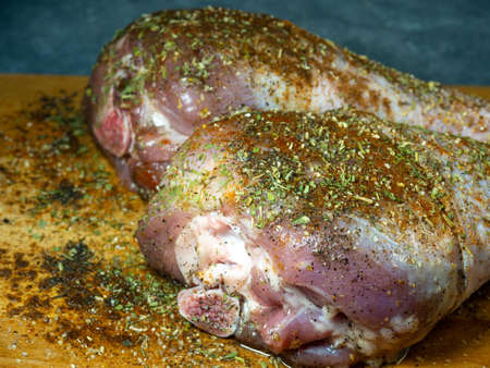 Turkey drumsticks in spices lie on a kitchen cutting board. Poultry meat. Turkey leg. Juicy meat is waiting to be cooked. Waiting for the oven. Hamの写真素材