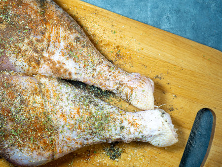 Turkey drumsticks in spices lie on a kitchen cutting board. Poultry meat. Turkey leg. Juicy meat is waiting to be cooked. Waiting for the oven. Hamの写真素材
