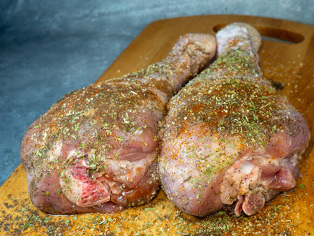 Turkey drumsticks in spices lie on a kitchen cutting board. Poultry meat. Turkey leg. Juicy meat is waiting to be cooked. Waiting for the oven. Hamの写真素材