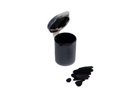 Tube with black gouache   on a white background. Drops of black paint.の写真素材