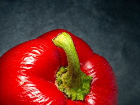 Red bell pepper on a black background. Harvest on the table. Wrinkled pepper.