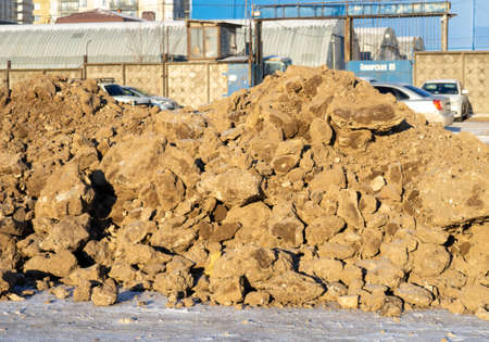 Blocks of frozen earth. A pile of earth. Cold weather. The consequences of digging a hole with an excavatorの写真素材