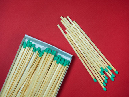 Large matches with green heads on a red background. Open matchboxの写真素材