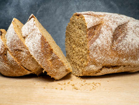 Sliced loaf of black bread on a kitchen board. Bread on a black background. Healthy food. Vegetarianismの写真素材