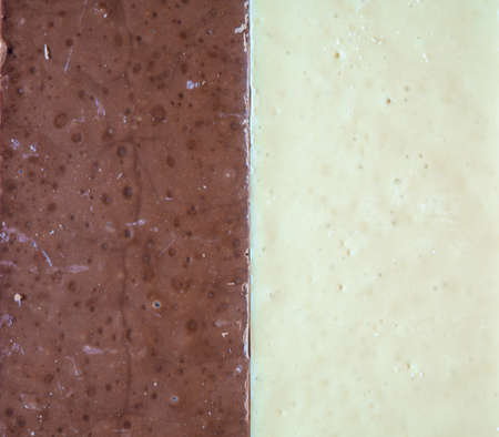 Dark and white chocolate. Chocolate background. Contrast of chocolate bars. Wedges of chocolateの写真素材