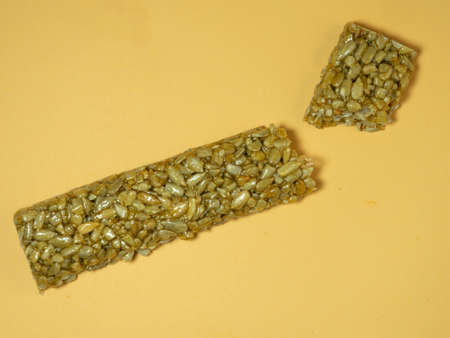 Broken tiles of Kozinaki. Pressed sunflower seeds in honey on a beige background.の写真素材