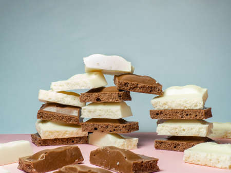 Turrets made of slices of black and white chocolate on a beige background. Slices from a bar of chocolate. Sweet slices backgroundの写真素材