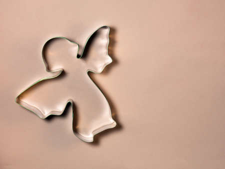 a baking dish in an angel's shape lies on a pink material. Preparing for Christmasの写真素材