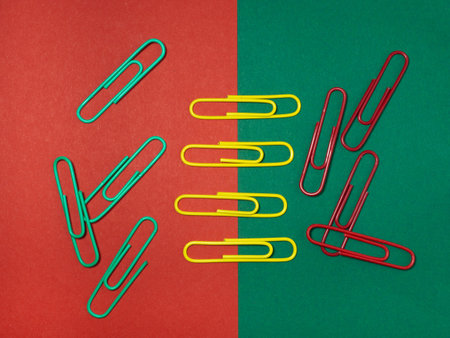 Colored paper clips on paper. Office supplies. Business goods. Colorful office supplies.の写真素材