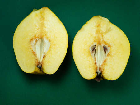 Sliced ââquince. Juicy fruit on a green background. Ripe useful product. Weathered fruit pulp. Nutrition on a dietの写真素材