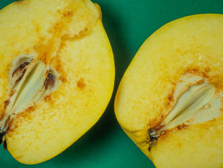 Sliced ââquince. Juicy fruit on a green background. Ripe useful product. Weathered fruit pulp. Nutrition on a dietの写真素材
