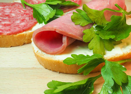 Sandwich with salami, beef, melted cheese and parsley. Homemade food. Food in a hurry. Snack for lunchの写真素材