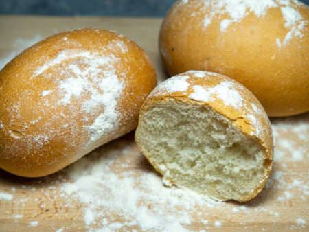 Bakery products. Table in the bakery. White bun on a cutting board. Products from wheat flour of the highest grade. Sliced ââbun. Airy pastry doughの写真素材