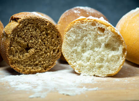 Bakery products. Table in the bakery. Buns on a cutting board. Rye and wheat buns. Products from premium wheat flour and rye flour.の写真素材