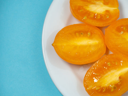 Sliced ââjuicy tomatoes on a plate. Greenhouse orange tomatoes. Health food. Vegetarian food. Still life vegetablesの写真素材