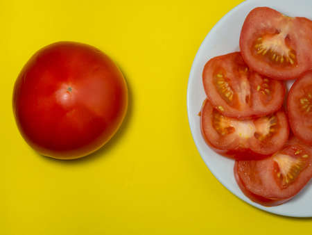 Cut juicy tomatoes of different varieties on a yellow background. Health food. Vegetarian food. Still life vegetablesの写真素材