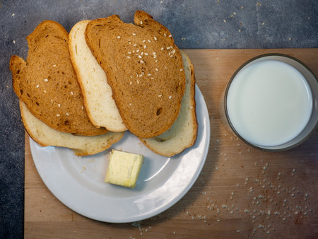 Sliced ââloaf bread for breakfast with butter. food on the table. Flour products. Pieces of bun in hand. Cooking dinnerの写真素材