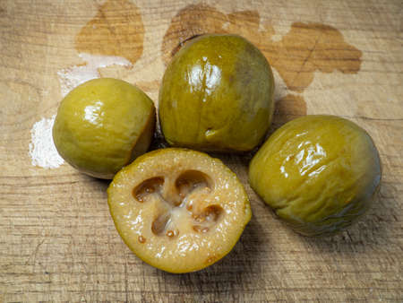Canned feijoa. The fruit of a tree with seeds. Compote preparation. Cut feijoa on the tableの写真素材