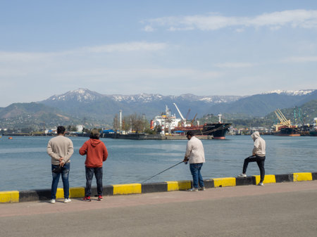 Batumi, Georgia. 04.20.2022 Girls on the pier. Sea coast. Port within the city. rocky shore. children by the seaのeditorial素材