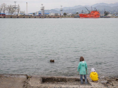 Batumi, Georgia. 04.20.2022 Girls on the pier. Sea coast. Port within the city. rocky shore. children by the seaのeditorial素材