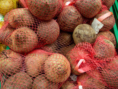 vegetable shop. Healthy foods. Beats on the counter. Showcase of vegetables. Sale of beets in string bags. Vitamin-containing productsの写真素材