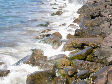 Surf. Waves crash on big rocks. rocky coast and wave. Powerful coastline. sea foam. The excitement of the sea. Huge coastal rocks.の写真素材