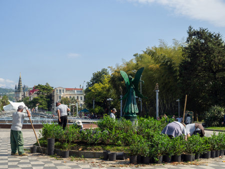 Batumi, Georgia. 05.30.2022 Landscaping of the park. Work in the garden. city gardener. Man at work. Planting plants in a beautiful park. Shovelのeditorial素材
