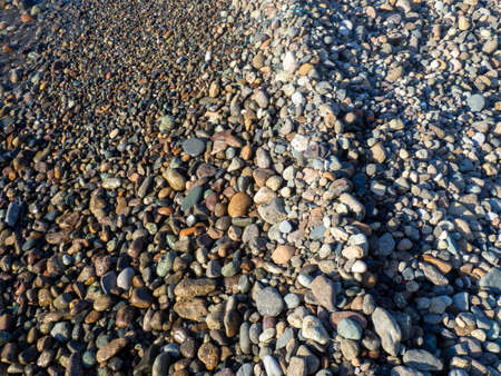 sea coastline close up. The shore is covered with pebbles. water lineの写真素材