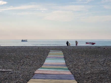 The road from multi-colored boards to the seashore. people on the coast. Rest on the sea. Relaxの写真素材