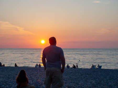 Batumi, Georgia. 10/06/2022 A man looks at the setting sun. Silence and peace. Rest on the sea. Relax. Sunsetの写真素材
