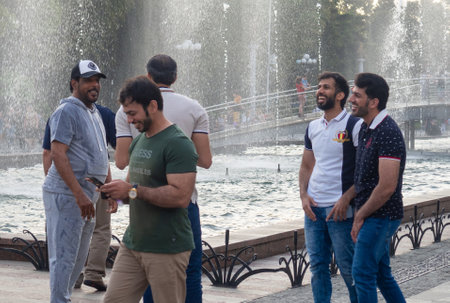 Batumi, Georgia. 06.10.2022 The men laugh at the fountain. Resting people. Good pastime. young people smilingのeditorial素材