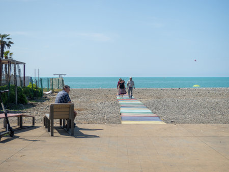Batumi, Georgia. 14/06/2022 People walk along the rocky beach. The holiday season is open. People by the water. black seaのeditorial素材
