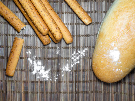 Sesame biscuits and bread on the table. Biscuits are elongated in the form of sticks. Bread products. Flour products.の写真素材