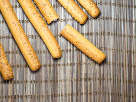 Sesame biscuits and bread on the table. Biscuits are elongated in the form of sticks. Bread products. Flour products.の写真素材