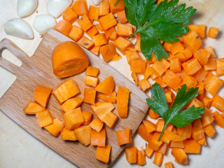 Finely chopped carrots and parsley leaves on the table. Cooking. Soup ingredients. Summer food. For a veggie lunch. Root crop on a cutting board.の写真素材